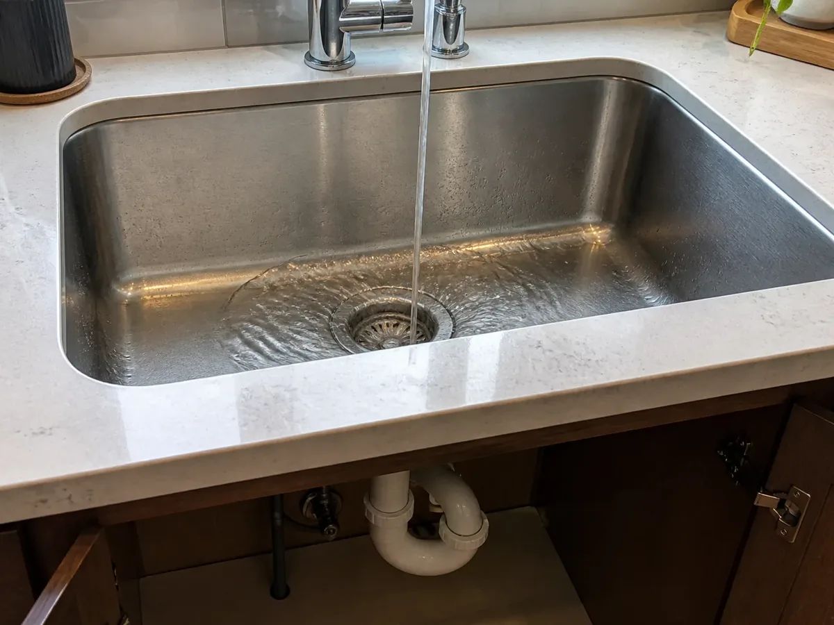 Water draining freely from a restored Seattle kitchen sink